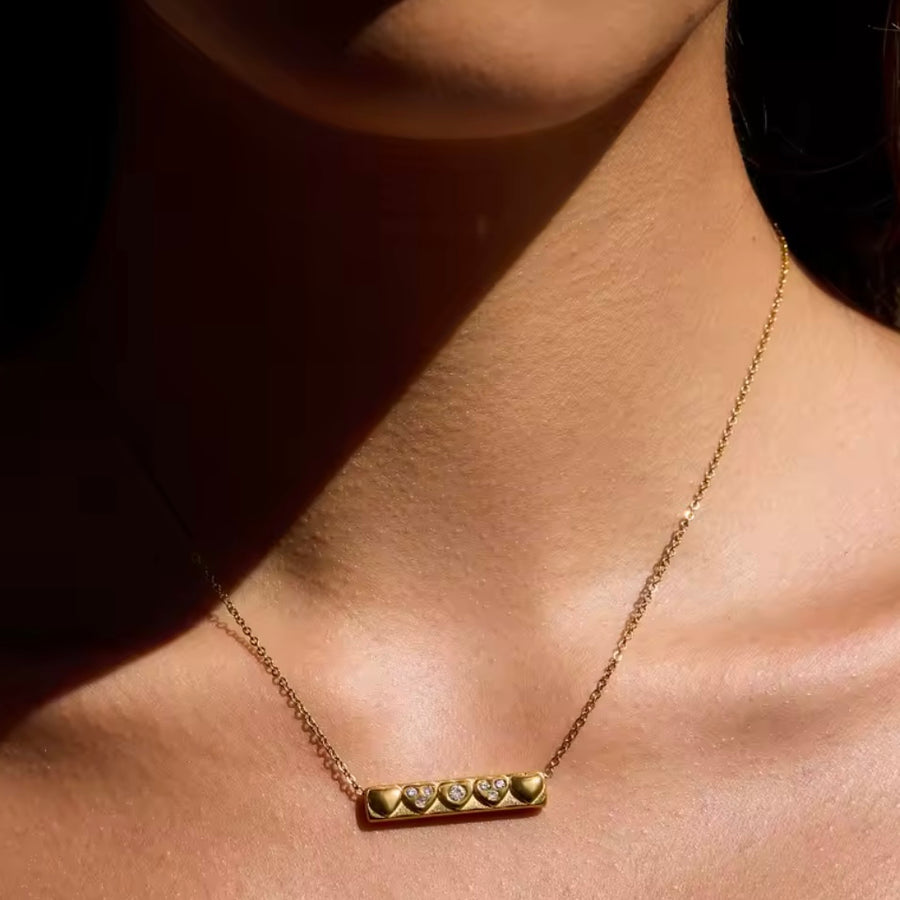 Gold bar necklace with heart details and clear crystal stones on fine chain