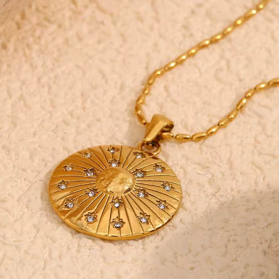 Gold sunburst pendant necklace with rhinestone four-pointed star on stainless steel chain